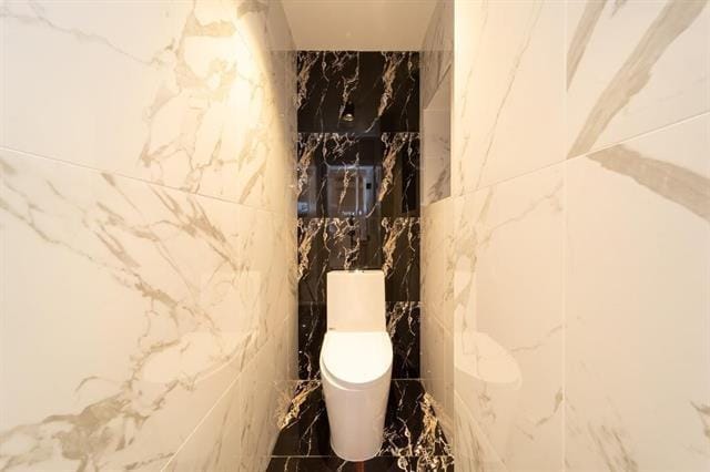 481 Martin Luther King Jr Dr, Jersey City, NJ 07304 - bathroom featuring toilet, stone wall, and marble finish floor