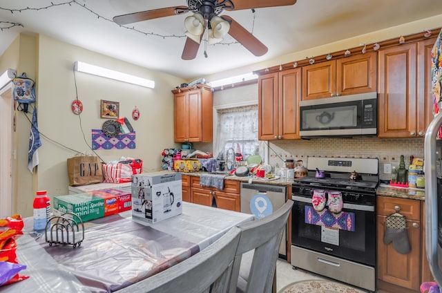 27 W 4th St, Bayonne, NJ 07002 - kitchen featuring appliances with stainless steel finishes, brown cabinets, ceiling fan, and tasteful backsplash
