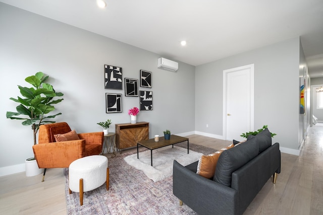 living room featuring a wall mounted air conditioner and light hardwood / wood-style flooring