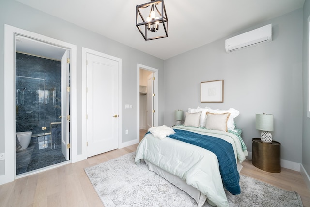 bedroom featuring light hardwood / wood-style floors, a chandelier, and an AC wall unit