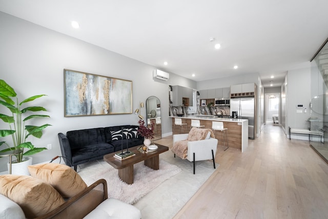 living room featuring a wall unit AC and light hardwood / wood-style flooring