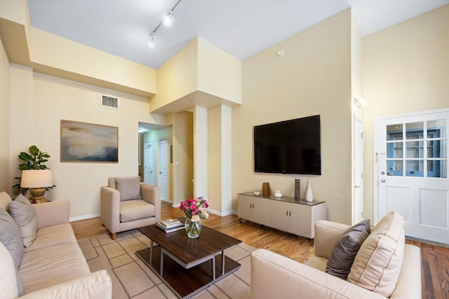 341 Monmouth St Unit 104D, Jersey City, NJ 07302 - living area featuring light wood-type flooring, a towering ceiling, and track lighting