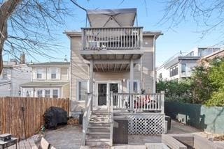 back of house featuring a wooden deck and a balcony