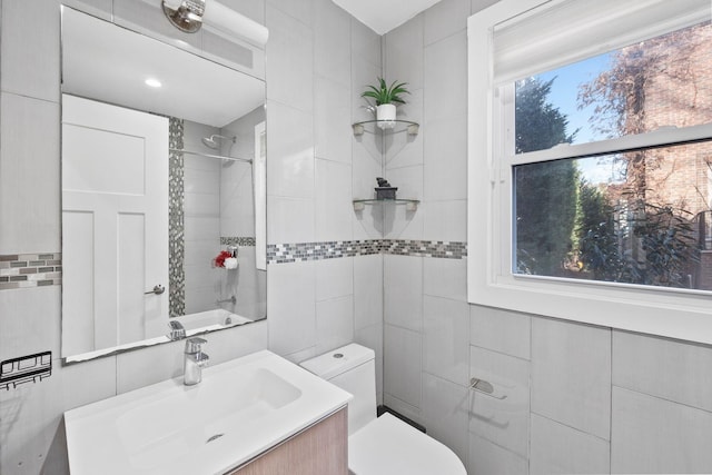 bathroom with walk in shower, vanity, tile walls, and toilet