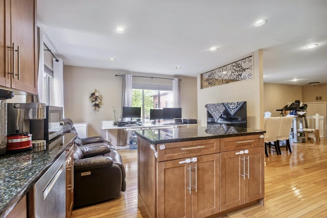 kitchen with light wood finished floors, open floor plan, dark stone countertops, and recessed lighting