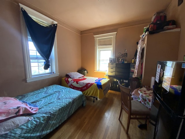 143 64th St, West New York, NJ 07093 - bedroom with freestanding refrigerator, wood finished floors, and multiple windows