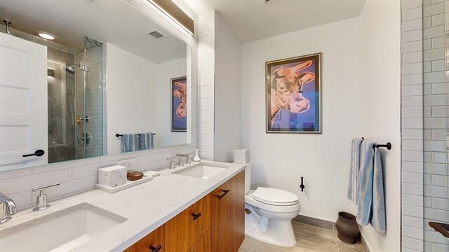 10 Provost St Unit 1004, Jersey City, NJ 07302 - bathroom featuring tiled shower, toilet, backsplash, double vanity, and baseboards
