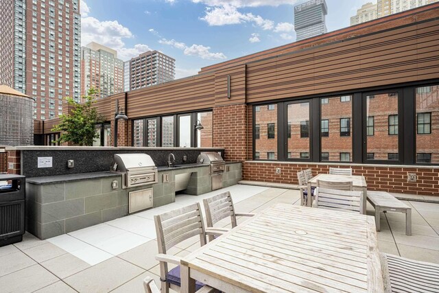 10 Provost St Unit 1004, Jersey City, NJ 07302 - view of patio featuring area for grilling, exterior kitchen, a city view, and a sink
