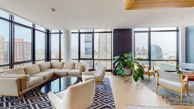 10 Provost St Unit 1004, Jersey City, NJ 07302 - living area with a city view, a wall of windows, wood finished floors, and plenty of natural light