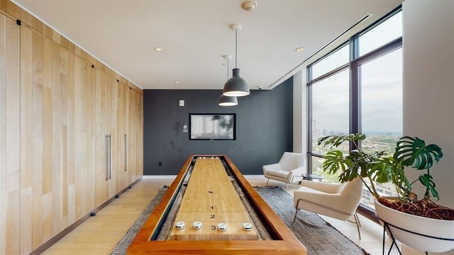 10 Provost St Unit 1004, Jersey City, NJ 07302 - recreation room with light wood-style flooring, floor to ceiling windows, wooden walls, baseboards, and an accent wall
