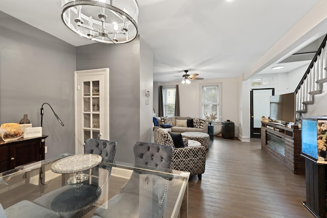 dining area with dark hardwood / wood-style floors and ceiling fan with notable chandelier