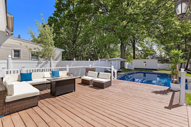 deck featuring an outdoor living space, a shed, a fenced backyard, and an outdoor structure