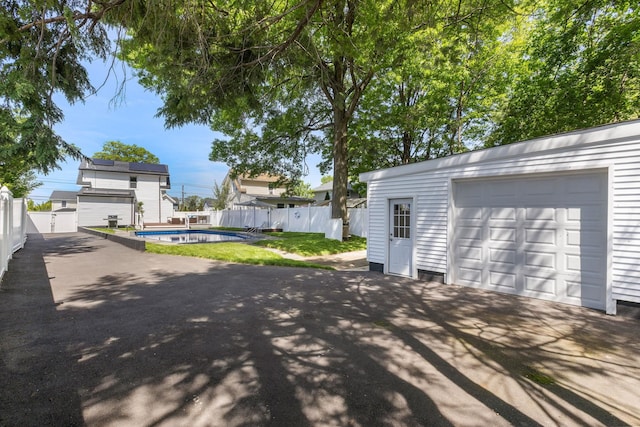 garage featuring fence and driveway