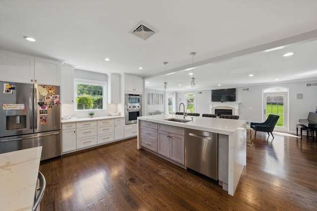 12 Stephen Pl, Little Falls, NJ 07424 - kitchen featuring appliances with stainless steel finishes, a sink, open floor plan, a fireplace, and dark wood finished floors