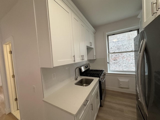311 79th St Unit 37, North Bergen, NJ 07047 - kitchen featuring freestanding refrigerator, stainless steel gas range oven, white cabinets, and plenty of natural light