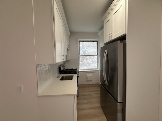 311 79th St Unit 37, North Bergen, NJ 07047 - kitchen with freestanding refrigerator, light countertops, white cabinets, light wood-style floors, and gas range