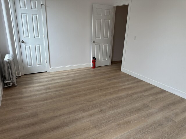 311 79th St Unit 37, North Bergen, NJ 07047 - unfurnished bedroom featuring radiator heating unit and light wood-style flooring