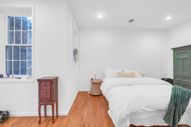 bedroom with light wood-style flooring, visible vents, baseboards, and recessed lighting