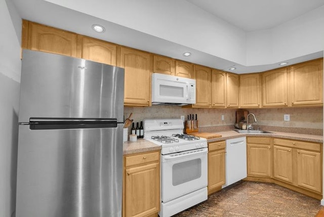 kitchen featuring recessed lighting, white appliances, a sink, light countertops, and decorative backsplash