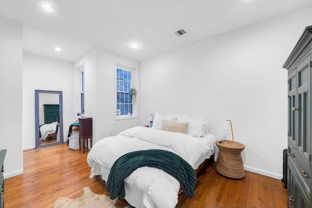 bedroom featuring light wood finished floors, visible vents, baseboards, and recessed lighting