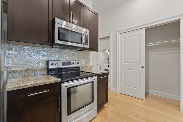 104 Tidewater St Unit 1A, Jersey City, NJ 07302 - kitchen with stainless steel appliances, dark brown cabinets, light wood-style flooring, decorative backsplash, and light stone countertops