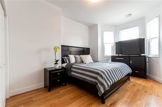 bedroom featuring multiple windows and light hardwood / wood-style floors