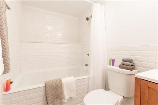 full bathroom featuring vanity, toilet, and shower / tub combo