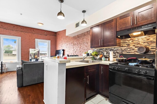 37 Harmon St, Jersey City, NJ 07304 - kitchen with a peninsula, under cabinet range hood, gas stove, light countertops, and a sink