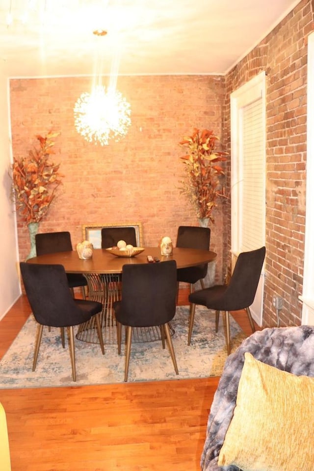37 Harmon St, Jersey City, NJ 07304 - dining space featuring a chandelier, brick wall, and wood finished floors