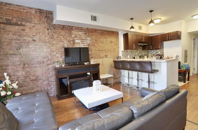 37 Harmon St, Jersey City, NJ 07304 - living room with visible vents, brick wall, light wood finished floors, and electric panel