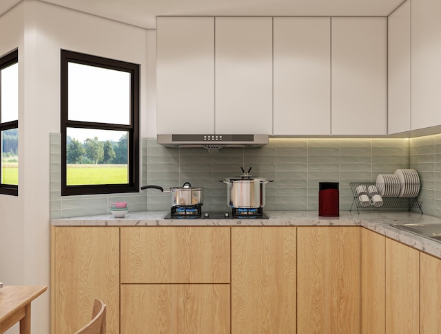 kitchen featuring white cabinets, light brown cabinets, tasteful backsplash, and light stone countertops