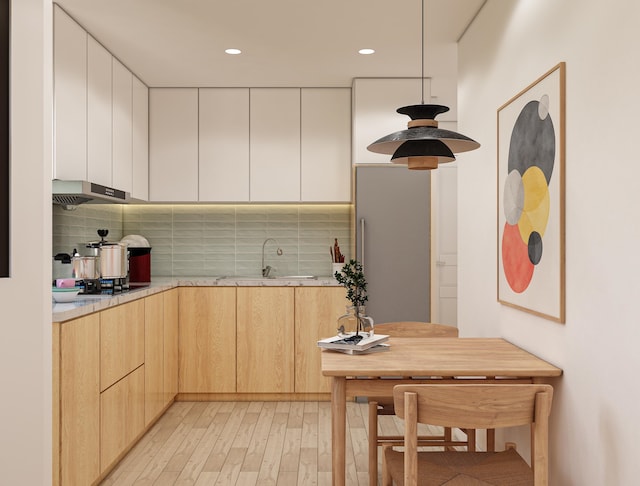 kitchen with black gas stovetop, light hardwood / wood-style floors, decorative backsplash, sink, and light brown cabinets