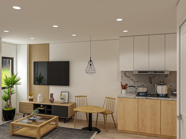 kitchen featuring light hardwood / wood-style floors, white cabinetry, tasteful backsplash, light brown cabinetry, and hanging light fixtures