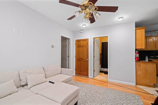 living room with ceiling fan and light wood-type flooring