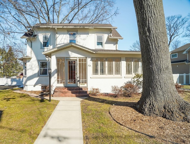 view of front facade featuring a front yard, fence, and stucco siding