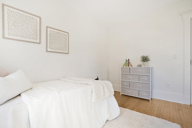 bedroom featuring baseboards and hardwood / wood-style flooring