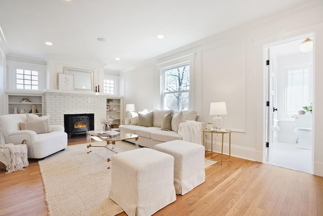 living room featuring a wealth of natural light, crown molding, and light wood finished floors