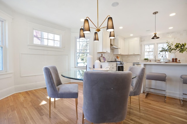 dining area featuring light wood finished floors, baseboards, and recessed lighting