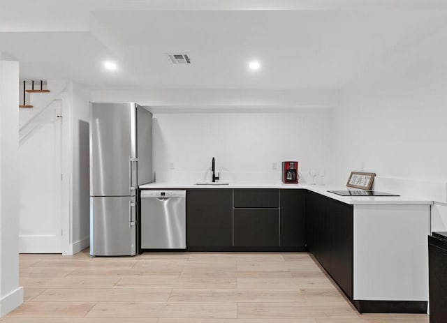 2602 Palisade Ave, Weehawken, NJ 07086 - kitchen featuring stainless steel appliances, light countertops, light wood-type flooring, recessed lighting, and dark cabinets