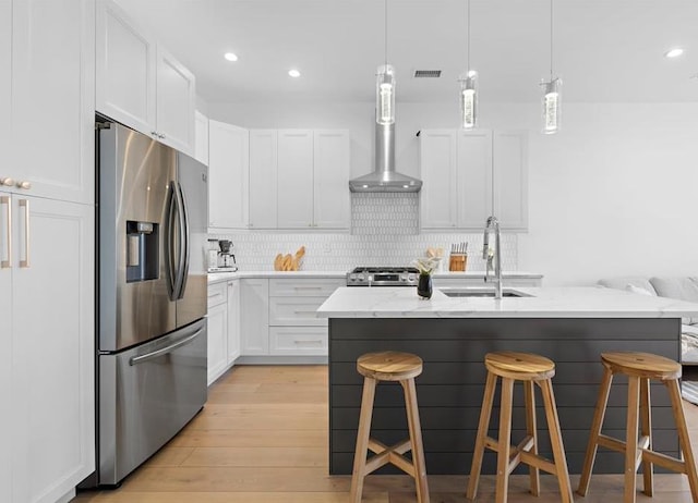 2602 Palisade Ave, Weehawken, NJ 07086 - kitchen featuring appliances with stainless steel finishes, a sink, wall chimney range hood, light wood-style flooring, and decorative backsplash
