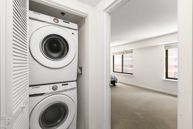 700 1st St Unit 6D, Hoboken, NJ 07030 - washroom featuring stacked washer / drying machine, carpet floors, and healthy amount of natural light