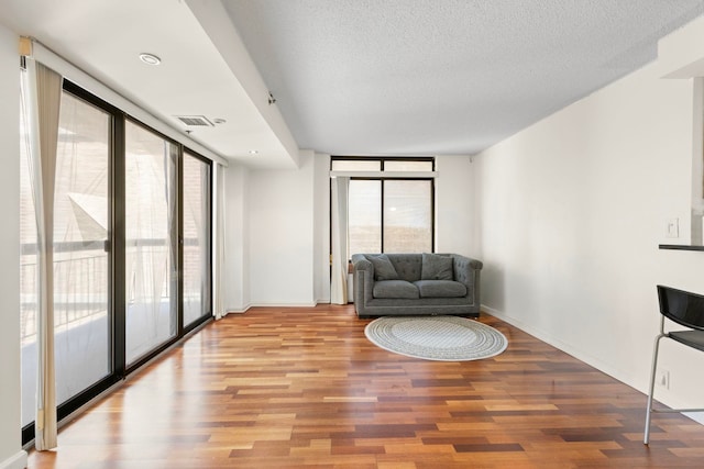 700 1st St Unit 6D, Hoboken, NJ 07030 - sitting room with plenty of natural light, light wood-style flooring, a textured ceiling, and floor to ceiling windows