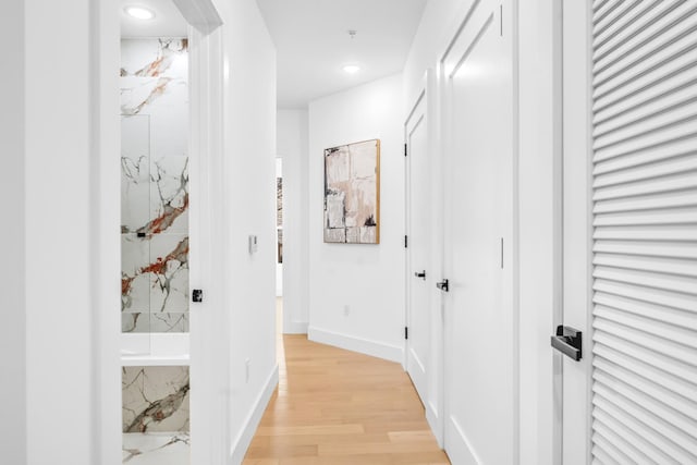 corridor with light wood-style floors, recessed lighting, and baseboards