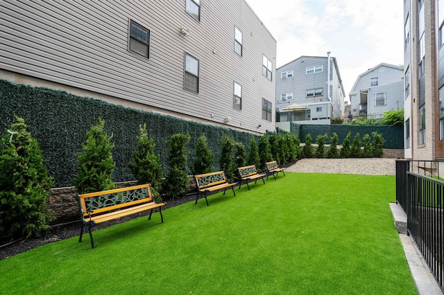 view of home's community with a yard, fence, and a residential view