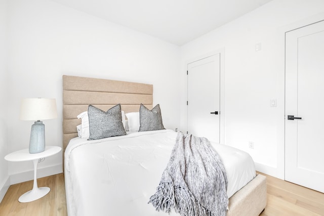 bedroom featuring baseboards and wood finished floors