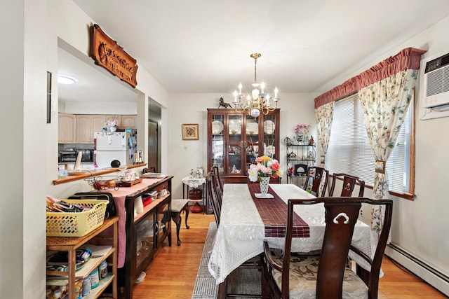 dining space with a wall unit AC, light wood-style floors, a chandelier, and a baseboard radiator