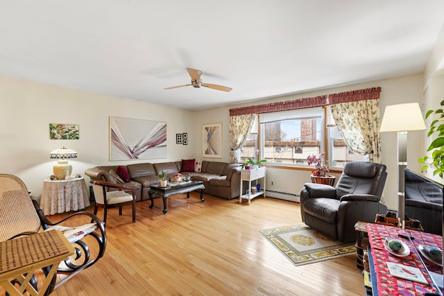 living room with baseboard heating, ceiling fan, and light wood-style floors