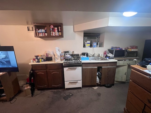 kitchen with dark brown cabinets, white range, and sink