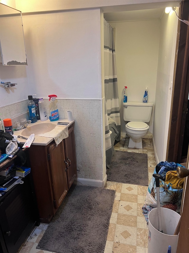 bathroom featuring tile walls, vanity, and toilet