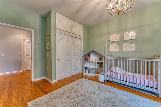 1200 Grand St Unit 220, Hoboken, NJ 07030 - bedroom featuring wood finished floors, a closet, a chandelier, and a nursery area